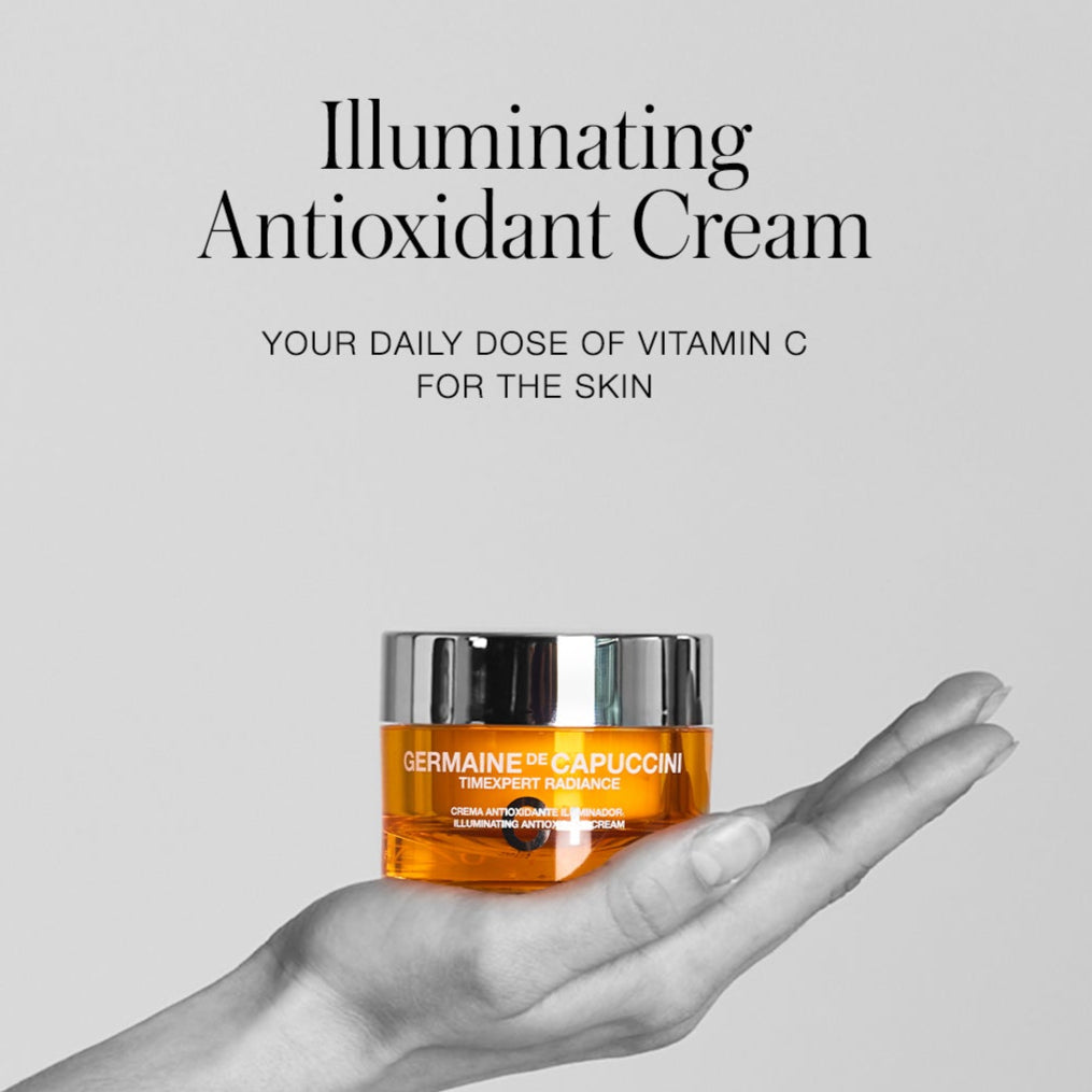 Jar of Germaine de Capuccini Illuminating Antioxidant Cream held in a hand with a gray background