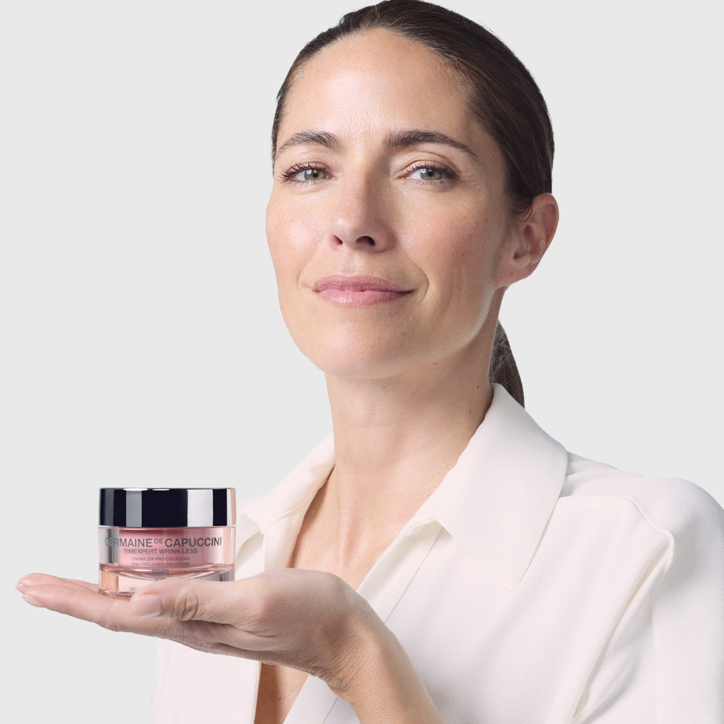 Woman holding a jar of anti-wrinkle product against a plain background