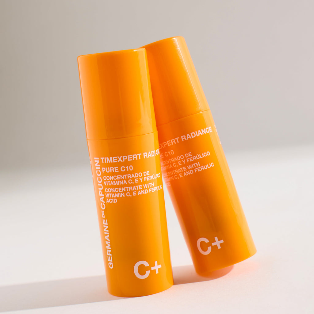 Two orange skincare products with text on a light gray background