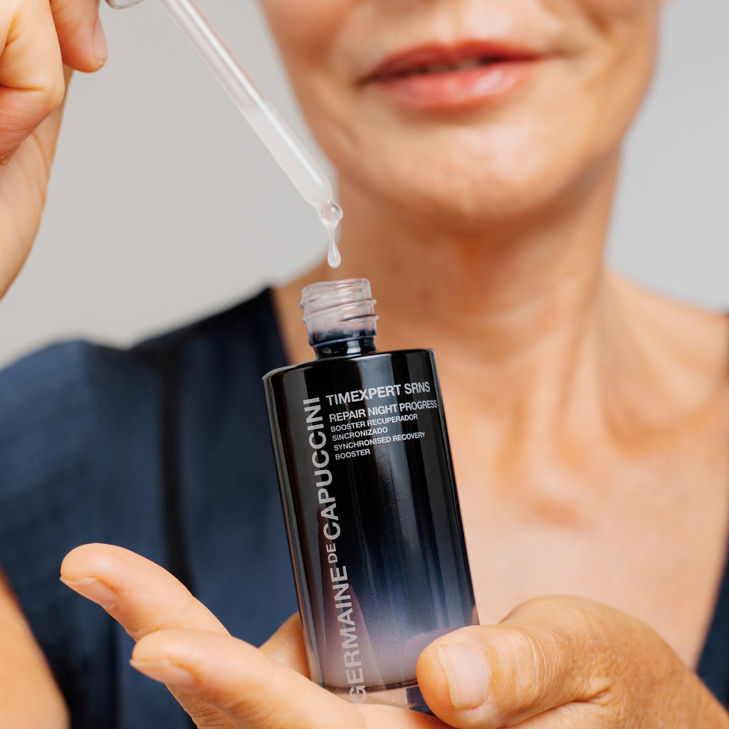 Person applying a skincare serum from a bottle labeled 'Dermatologist-Recommended' to their hand.