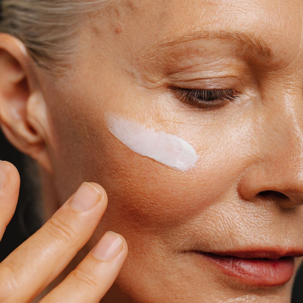 Close-up of a person applying cream to their face