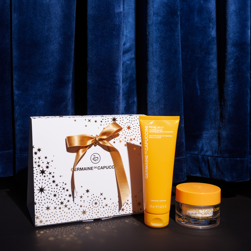 Germaine de Capuccini skincare products with a Christmas box against a blue curtain background